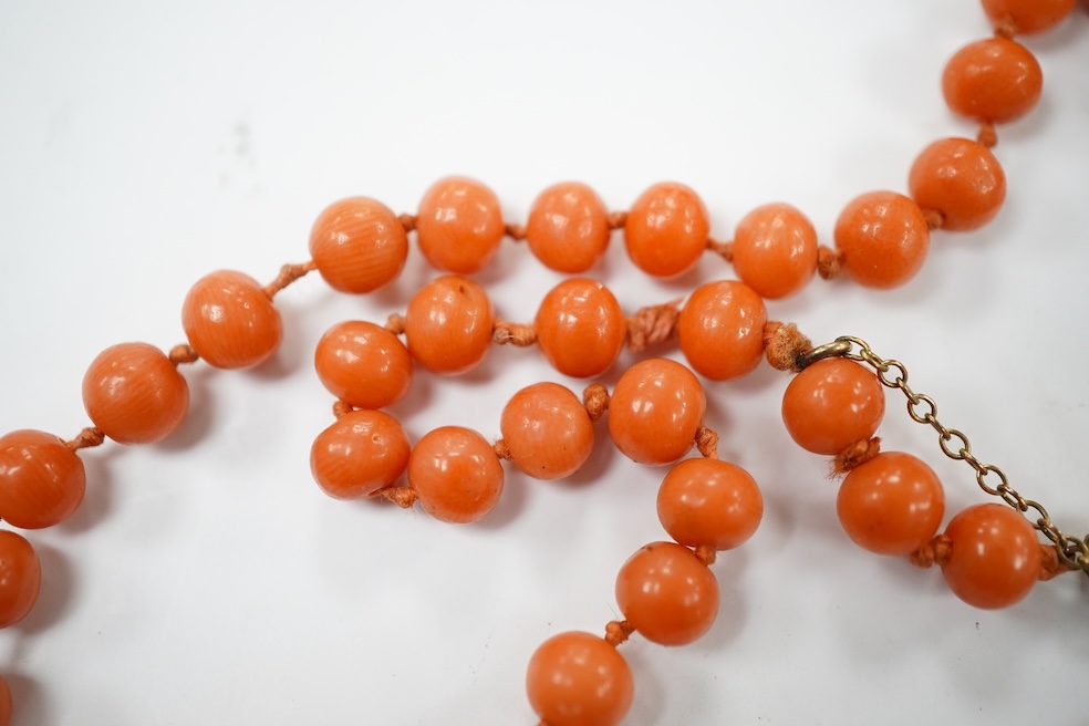 A single strand coral bead necklace, with a coral pendant carved as the face of a gentleman, overall 48cm. Condition - fair